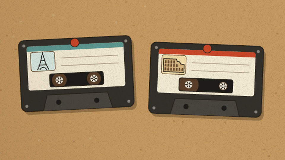 Two cassette tapes pinned to the cork: Eiffel Tower sticker and Colosseum sticker